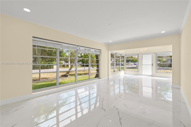 unfurnished room featuring a wealth of natural light and crown molding