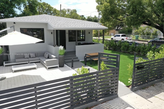 back of house with outdoor lounge area and a lawn