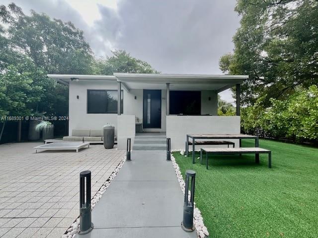 back of house featuring a lawn