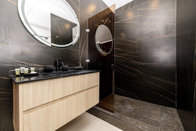 bathroom featuring walk in shower, vanity, tile walls, and tile patterned floors