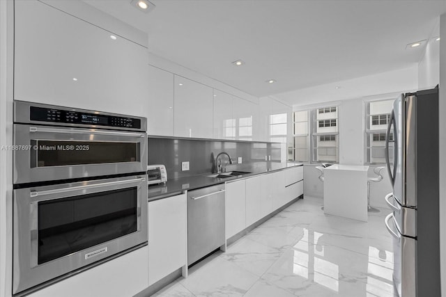 kitchen featuring sink, white cabinets, a center island, and appliances with stainless steel finishes