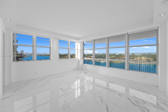 unfurnished sunroom featuring a water view