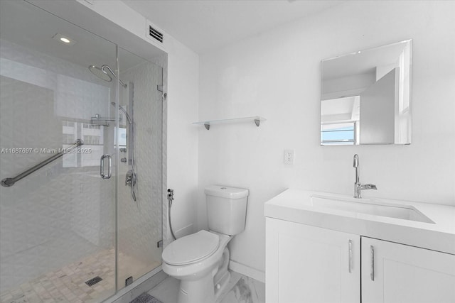 bathroom with a shower with shower door, vanity, and toilet