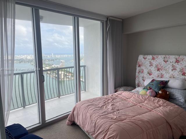 bedroom with floor to ceiling windows, carpet, and access to exterior