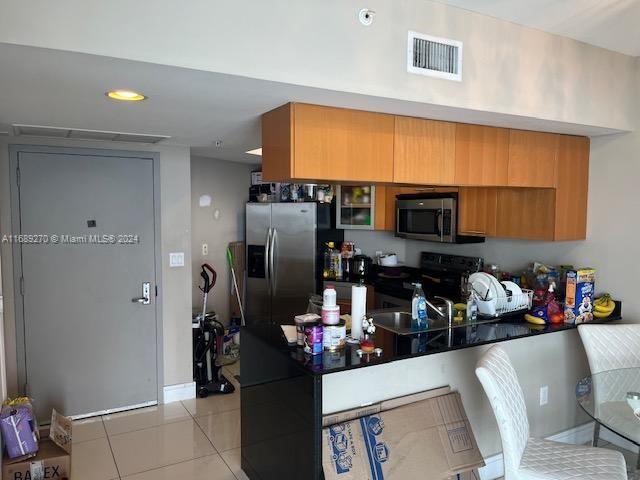 kitchen featuring sink, light tile patterned floors, and stainless steel appliances