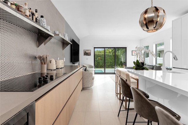 kitchen featuring sink, a breakfast bar area, pendant lighting, white cabinetry, and wine cooler