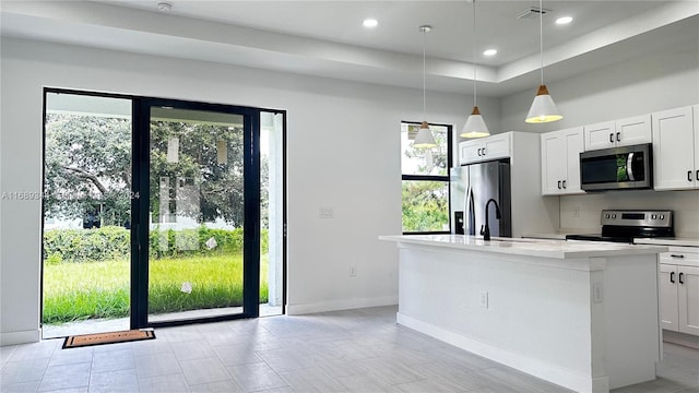 kitchen with plenty of natural light, white cabinets, hanging light fixtures, and stainless steel appliances