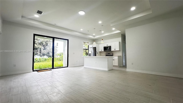 unfurnished living room with a tray ceiling