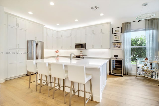 kitchen featuring white cabinets, light wood-type flooring, and appliances with stainless steel finishes