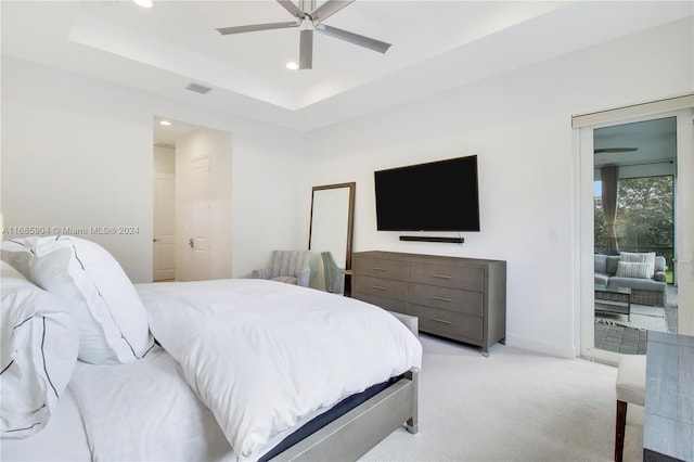 bedroom featuring a tray ceiling, light colored carpet, ceiling fan, and access to exterior