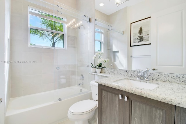 full bathroom featuring bath / shower combo with glass door, vanity, and toilet