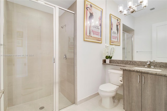 bathroom with vanity, a shower with shower door, tile patterned floors, and toilet