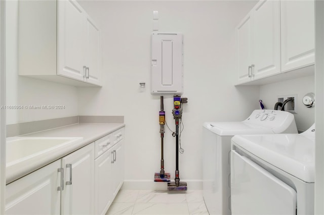 clothes washing area with separate washer and dryer, electric panel, and cabinets