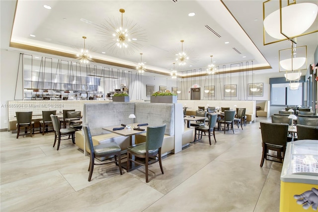 dining space featuring a raised ceiling and an inviting chandelier