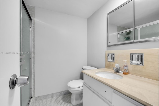 bathroom with an enclosed shower, vanity, tile patterned flooring, and toilet