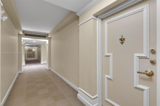 corridor featuring ornamental molding and light carpet