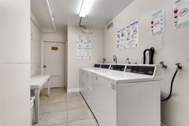 clothes washing area with light tile patterned floors and independent washer and dryer