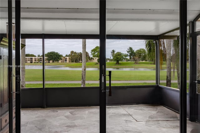 unfurnished sunroom featuring a water view