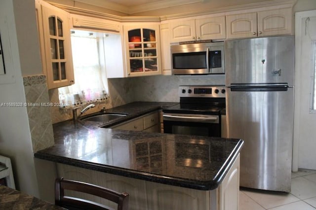 kitchen featuring tasteful backsplash, crown molding, appliances with stainless steel finishes, light tile patterned floors, and kitchen peninsula