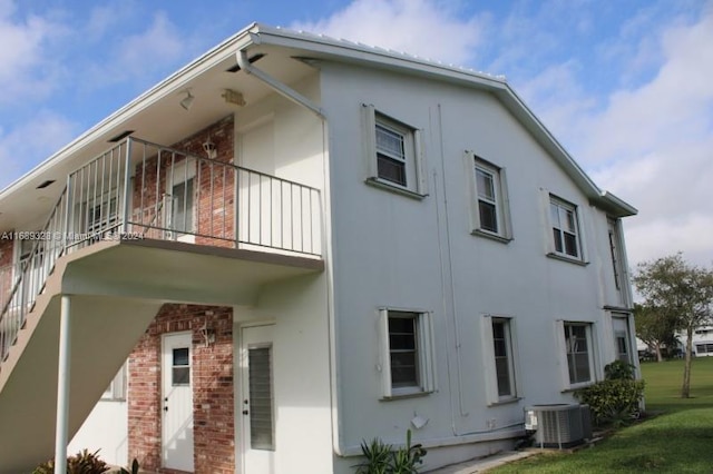 view of side of property with a balcony and central AC