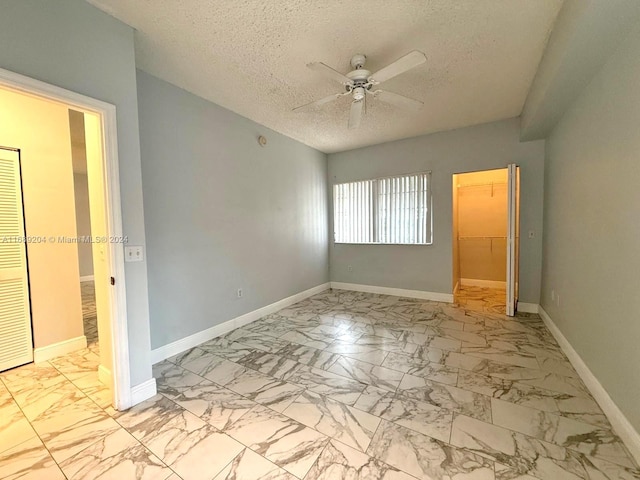 spare room featuring ceiling fan and a textured ceiling