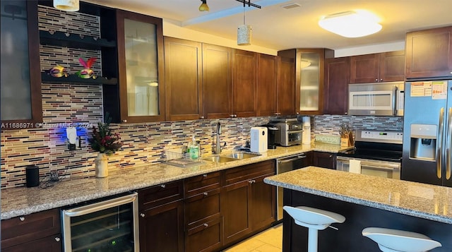 kitchen featuring decorative backsplash, stainless steel appliances, beverage cooler, and sink