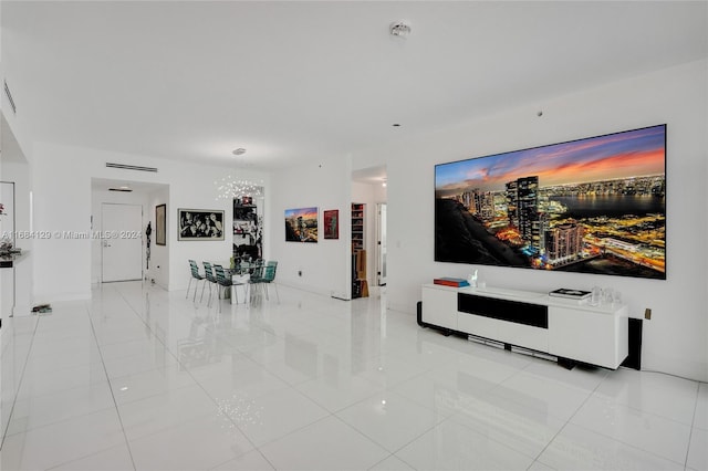 tiled living room featuring a notable chandelier