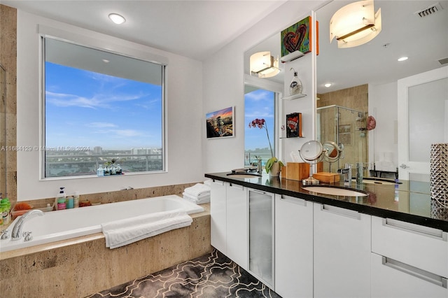 bathroom with tile patterned flooring, vanity, and plus walk in shower