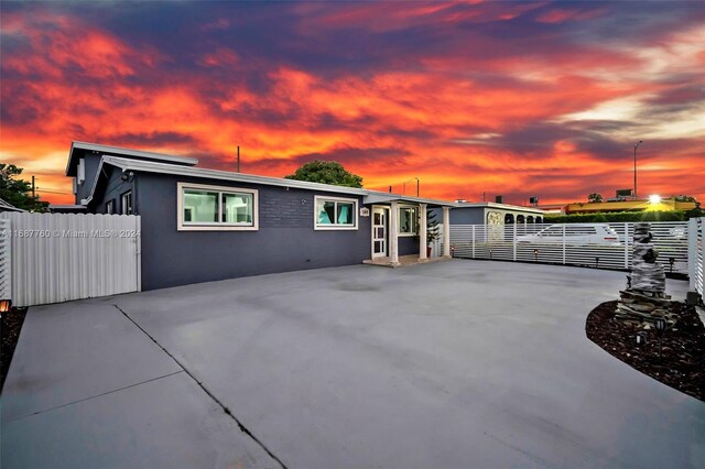 back house at dusk featuring a patio area