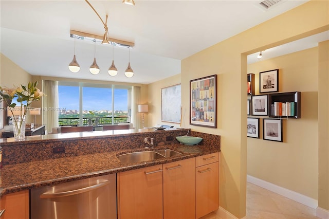 kitchen with dishwasher, sink, hanging light fixtures, and dark stone countertops