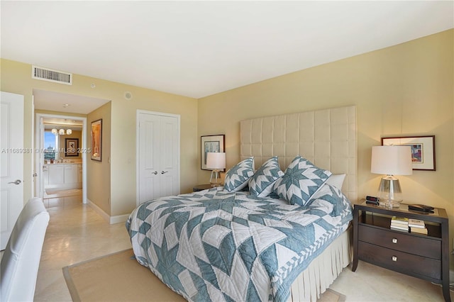 bedroom with light tile patterned floors, a closet, visible vents, and baseboards