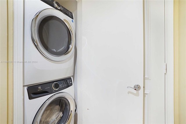 clothes washing area with stacked washer / dryer