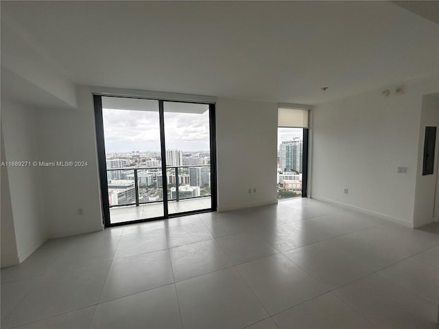 tiled spare room with floor to ceiling windows