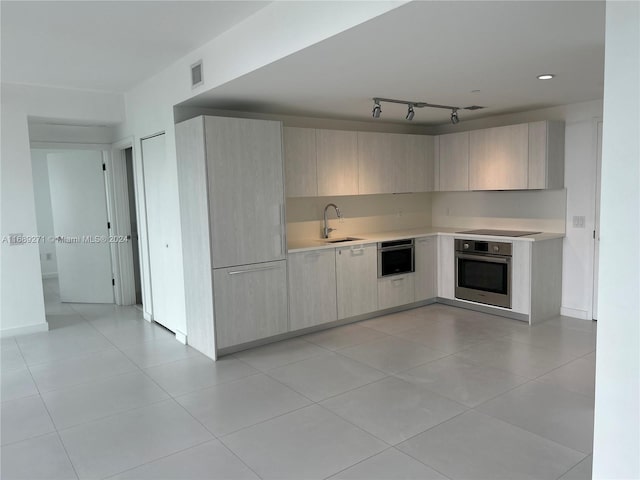 kitchen featuring oven, sink, light tile patterned floors, and black electric stovetop