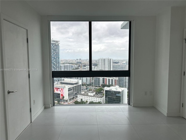 empty room featuring a wealth of natural light and light tile patterned floors