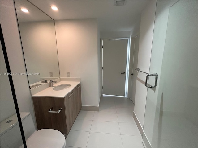 bathroom with tile patterned flooring, vanity, and toilet