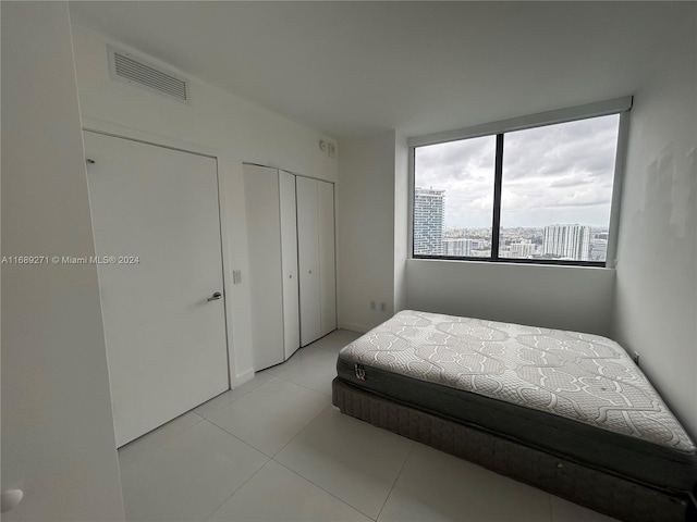 tiled bedroom with multiple closets