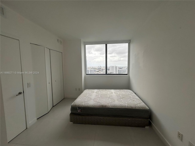 tiled bedroom featuring two closets