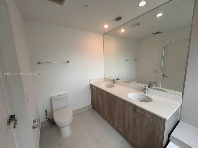 bathroom with tile patterned flooring, vanity, and toilet