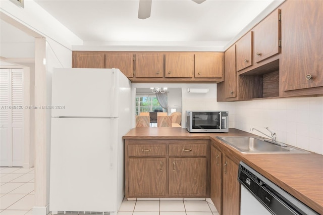 kitchen with white appliances, sink, backsplash, and light tile patterned flooring