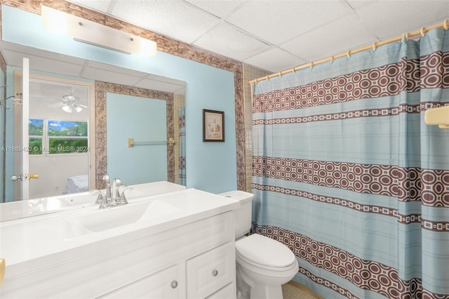 bathroom with toilet, a paneled ceiling, vanity, and ceiling fan