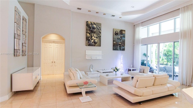 tiled living room featuring a high ceiling