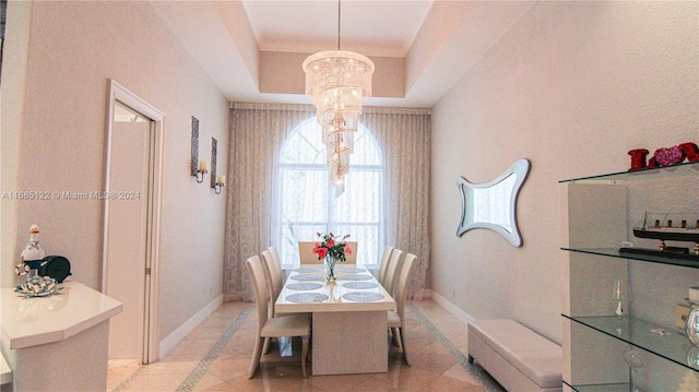 tiled dining area with a notable chandelier and a raised ceiling