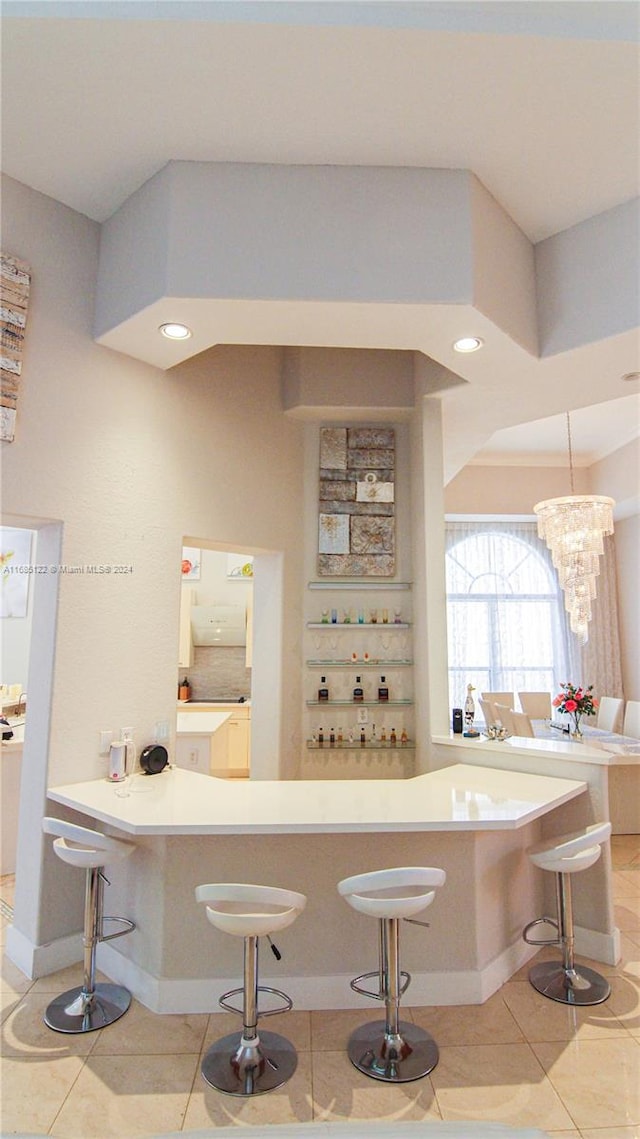 bar with light tile patterned floors, pendant lighting, and a notable chandelier