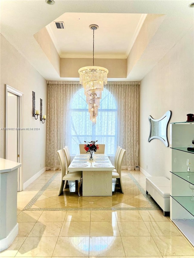 dining room featuring a chandelier, a tray ceiling, and ornamental molding