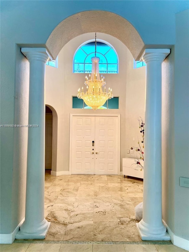 foyer entrance featuring a chandelier and a towering ceiling