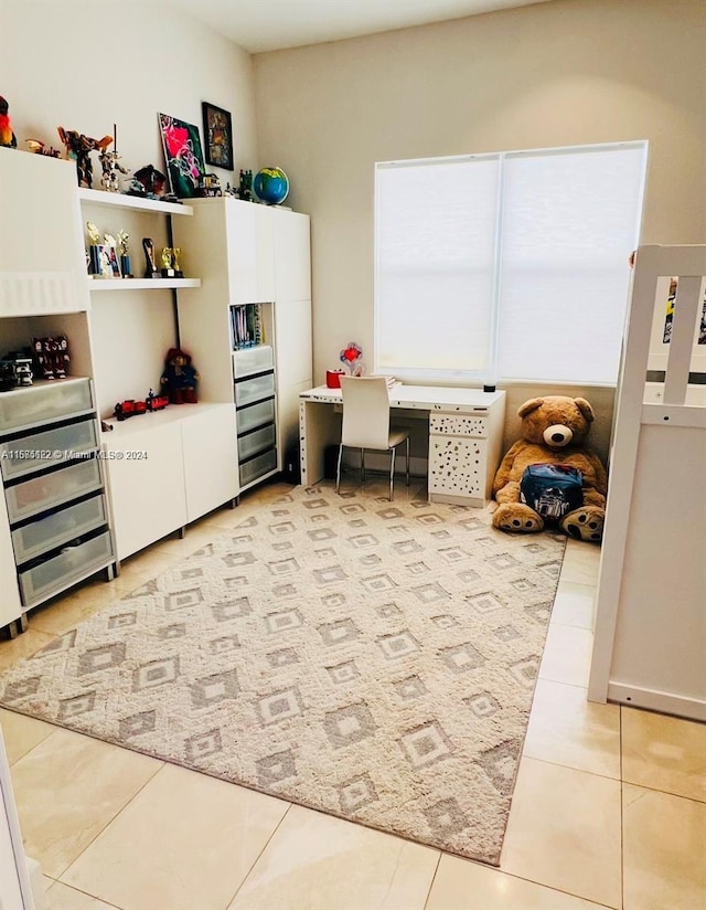 rec room with light tile patterned floors and built in desk