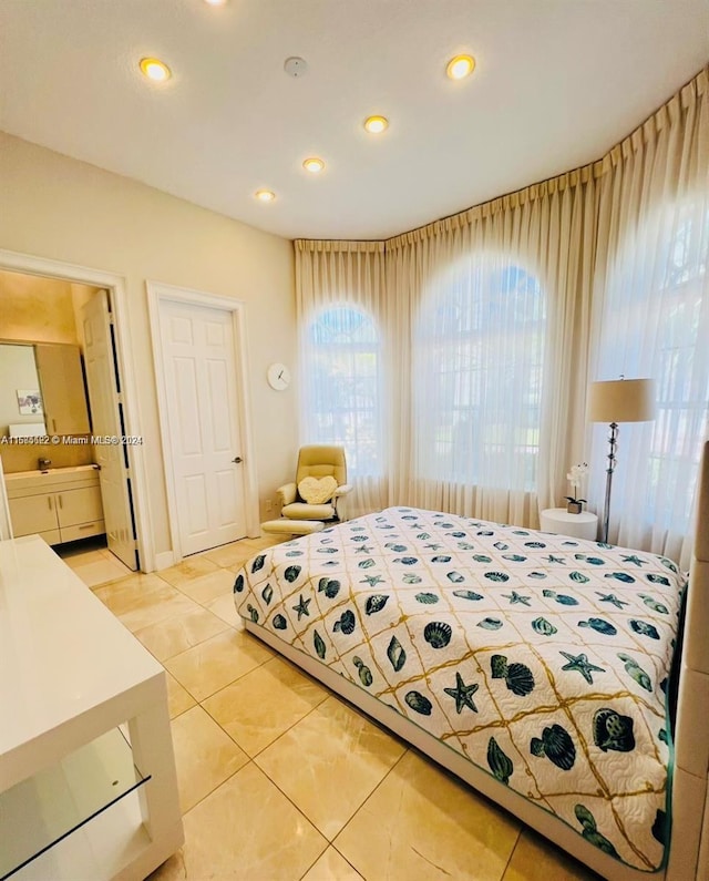 bedroom featuring connected bathroom and light tile patterned floors