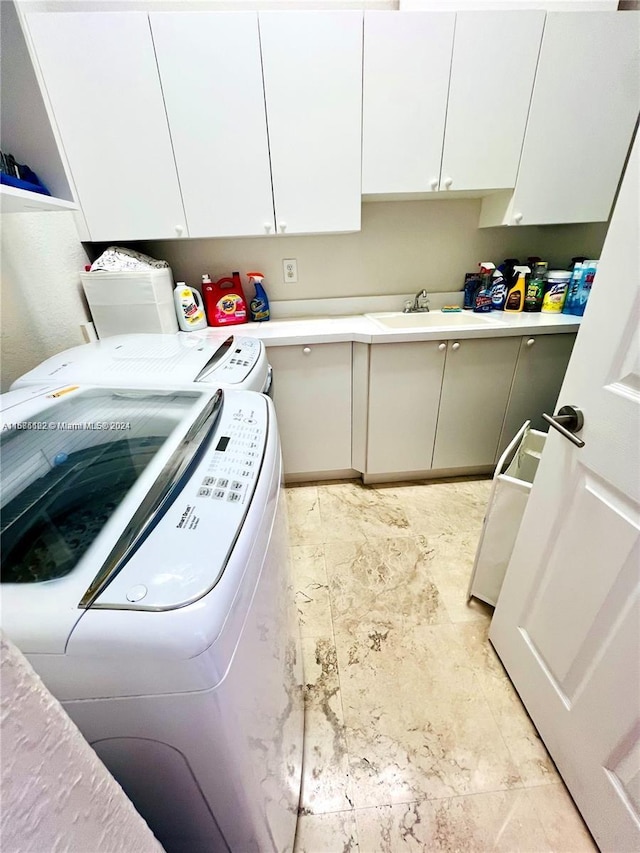 laundry room with cabinets, sink, and separate washer and dryer