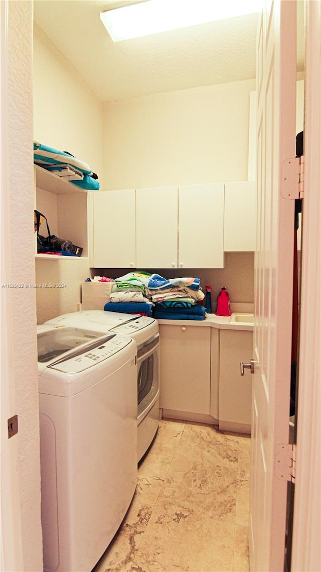 washroom featuring cabinets and independent washer and dryer